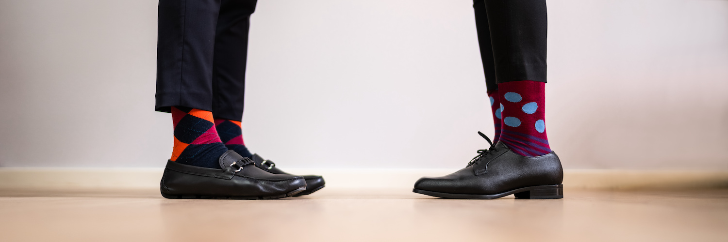 deux paires de pieds face à face portant des chaussettes et des chaussures de cuir