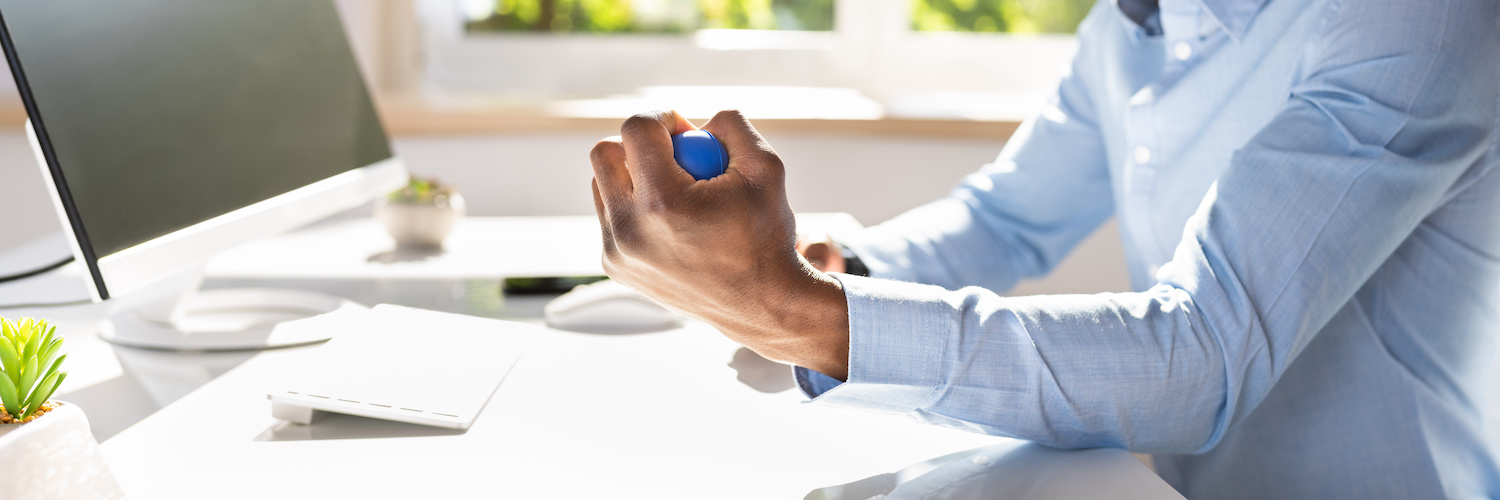 Homme pressant une balle anti-stress au travail